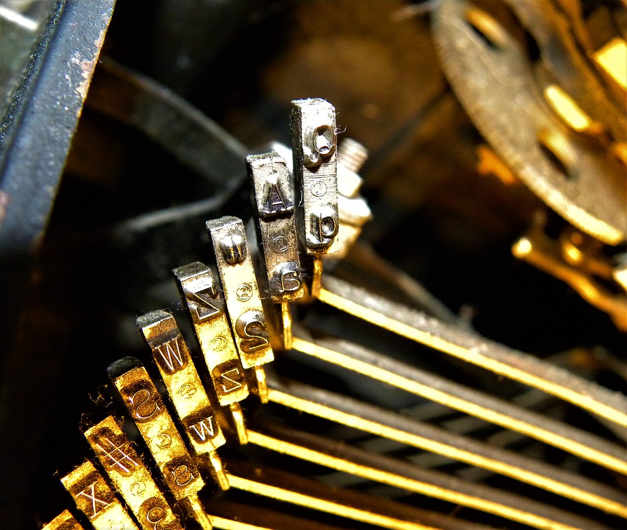 Close-up of the keyslugs on a vintage typewriter, showing worn lettering.